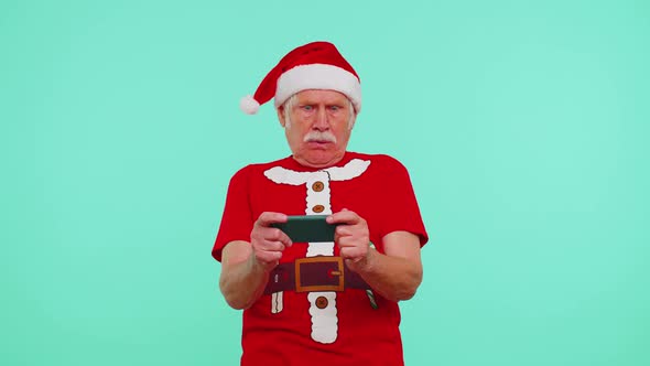 Worried Grandfather in Christmas Tshirt Enthusiastically Playing Racing Video Games on Mobile Phone