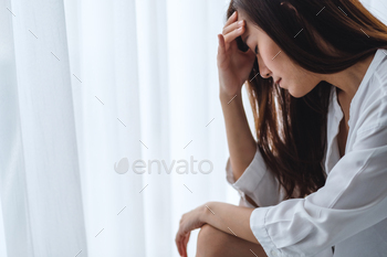 寝室で一人で座っている悲しくてストレスの多い若いアジアの女性 / Photodune, Misc