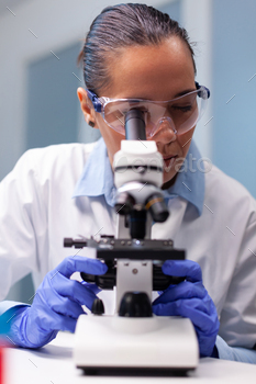 医療用顕微鏡を使用してコロナウイルスの遺伝子検査を見ている科学者の女性医師 / Photodune, Misc