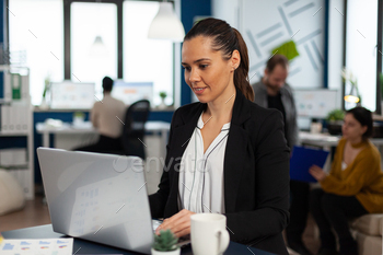 Enthusiastic woman manager browsing on internet using laptop / Photodune, Misc