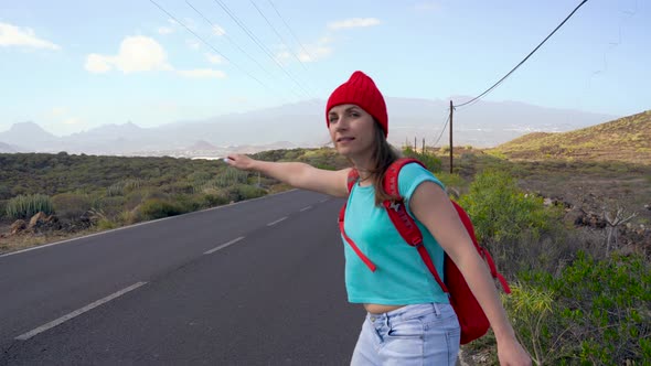 Traveler Woman Hitchhiking on a Sunny Road and Walking