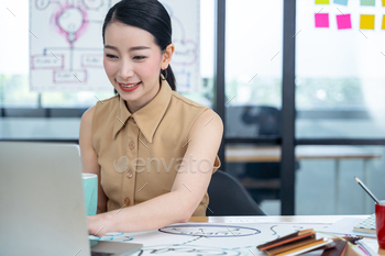 現代の創造的なオフィスでラップトップを使用して作業しているアジアの女性。 / Photodune, Misc