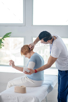 Professional male therapist doing massage for his patient