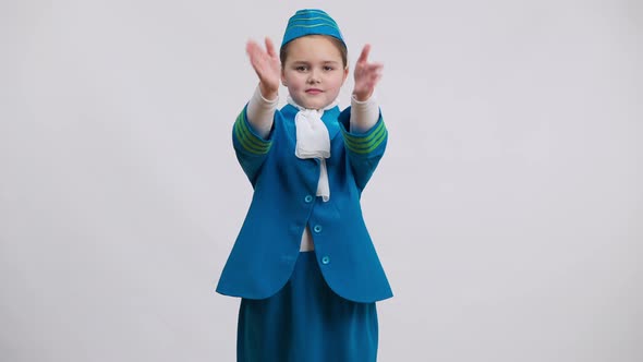 Portrait of Confident Smiling Little Air Hostess in Uniform Gesturing Showing Emergency Exits