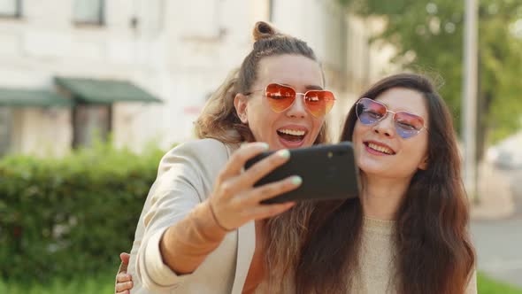 Positive Emotions and Love. Two Young Smiling Hipster Blond Women Taking Selfie Self Portrait Photos