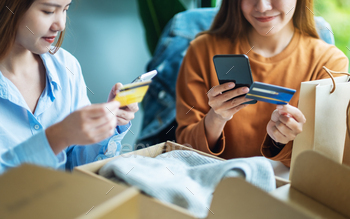 ショッピングバッグでオンラインショッピングに携帯電話とクレジットカードを使用している2人の女性 / Photodune, Misc