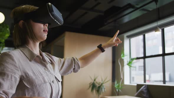 Asian businesswoman standing using vr googles in a modern office