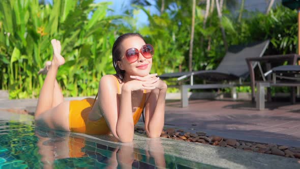 Young asian woman enjoy around outdoor swimming pool for leisure