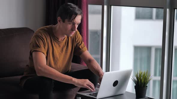 Happy Young Man Using Laptop Computer for Ecommerce Doing Online Shopping Watching Video Movie