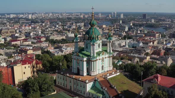 Beautiful flight over St. Andrew's Church in Kiev. Top view of Podol. Many buildings and churches.