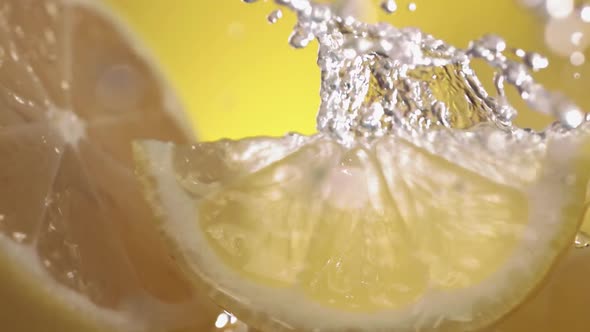 Slow Motion Shot of Lemon and Water Splashing Through Lemon Slices