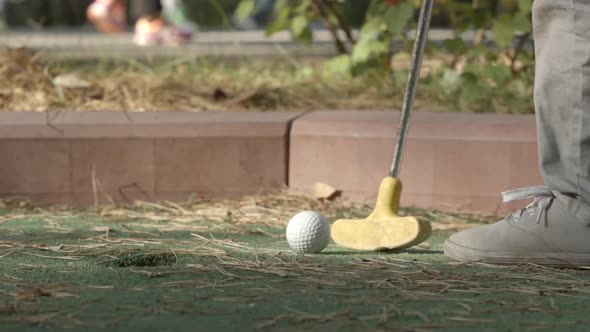 Little Player Beats A Golf Ball To Hole Course