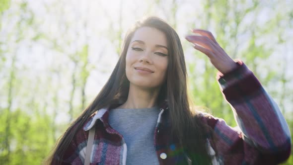 A Beautiful and Carefree Young Woman Walks in the Park in Spring