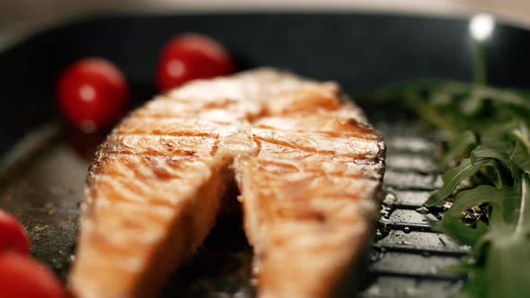 A Salmon Fillets on a Grill Plate with Herbs and Vegetables