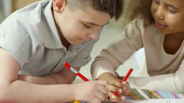 Little Caucasian Boy and African Girl Drawing Picture Together