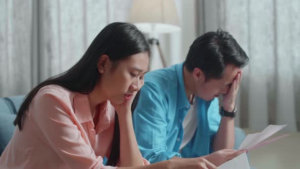 Asian Couple With A Laptop Arguing About The Bill Then Having Headache Due To Financial Problem