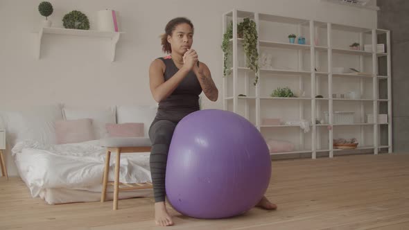 Determined Female Exercising with Fitball at Home