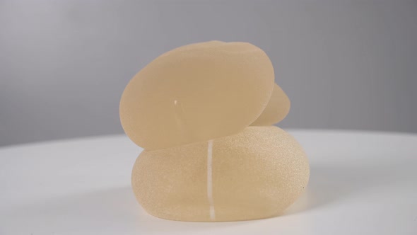Four Silicone Implants are Spinning on a White Background