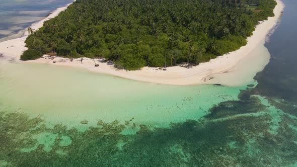 Panorama of the green Maldivian island washed by turquoise water from all sides under a beautiful sk