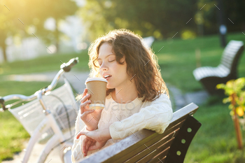朝の公園でコーヒーを飲んでいるかなり若い女の子 / Photodune, Misc