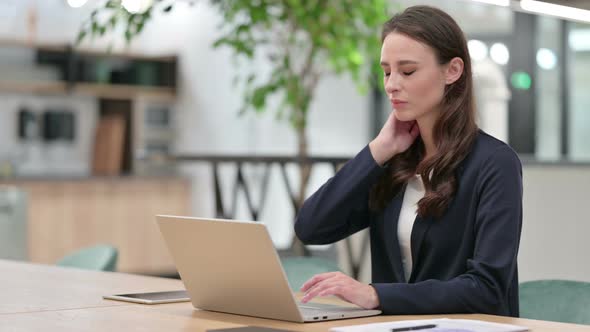 Businesswoman with Neck Pain Using Laptop at Work 