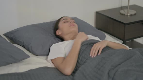 Hispanic Woman Feeling Uncomfortable while Sleeping in Bed