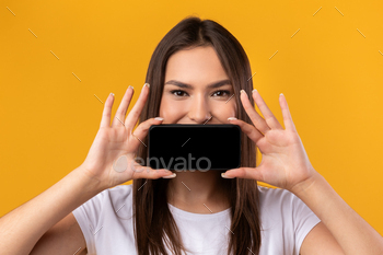 黒の空のスマートフォン画面で口を覆う女性 / Photodune, Misc