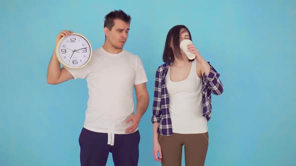 Sleepy Yawning Married Couple in the Morning Paper Cup of Coffee in Hand Looking at the Camera