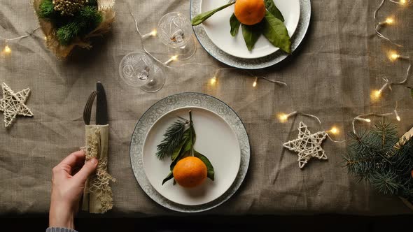 Young Woman Puts Cutlery on Festive Table