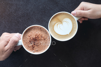 木製のテーブルとコーヒーとホットチョコレートカップを保持している男性と女性の手 / Photodune, Misc