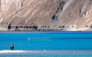 山の景色の背景とパンゴン湖の風景画像を持つ2人の観光客 / Photodune, Misc