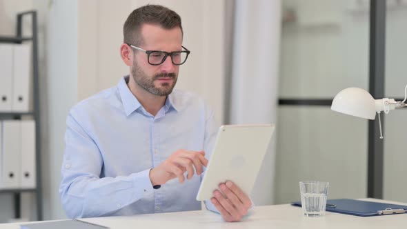 Middle Aged Man Disappointed By Loss on Tablet