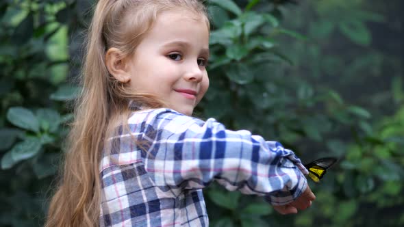 A Beautiful Girl is Standing with Her Back Turning There is a Butterfly on Her Hand