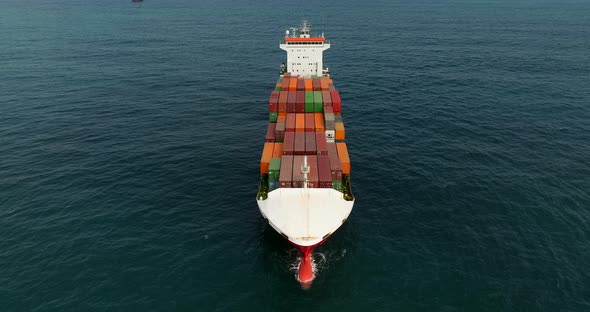 Container ship loaded with Shipping containers holding position at sea.