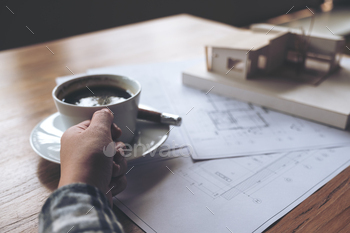 コーヒーを飲みながら紙を描く店で建築モデルに取り組んでいる建築家 / Photodune, Misc