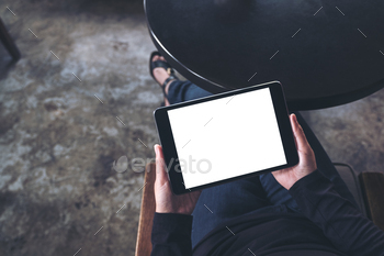 足を組んで座って、空白の白いデスクトップ画面で黒いタブレットPCを保持している女性 / Photodune, Misc