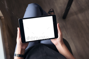 足を組んで座って、空白の白いデスクトップ画面で黒いタブレットPCを保持している女性 / Photodune, Misc