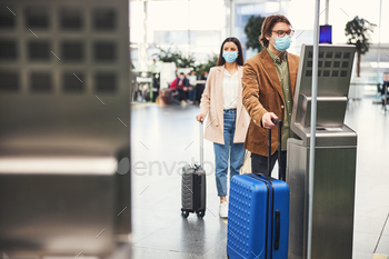 空港で手荷物チェック計量機を使用して医療マスクの男 / Photodune, Misc