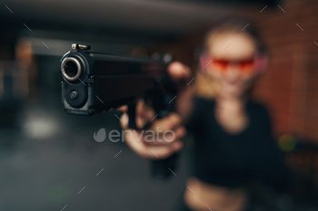 片手でピストルを撃つ安全ゴーグルの白人女性 / Photodune, Misc