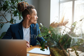 自宅でラップトップに取り組んでいるハンサムな若い男 / Photodune, Misc