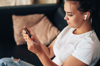 Girl in headphones holding smartphone / Photodune, Misc