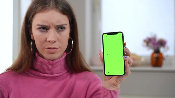 Closeup Chromakey Smartphone in Hand of Dissatisfied Young Woman Shaking Head