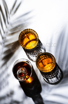 American bourbon whiskey in glasses and bottle, white  background with shadow pattern / Photodune, Misc