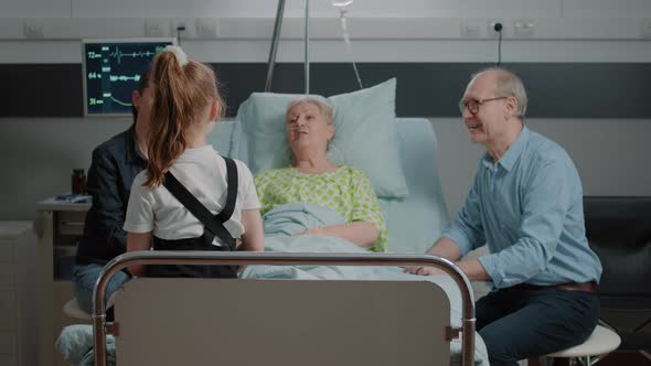 Retired Patient Talking to Niece at Family Visit in Hospital Ward