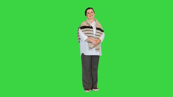 Mature Woman Standing and Smiling To Camera on a Green Screen Chroma Key