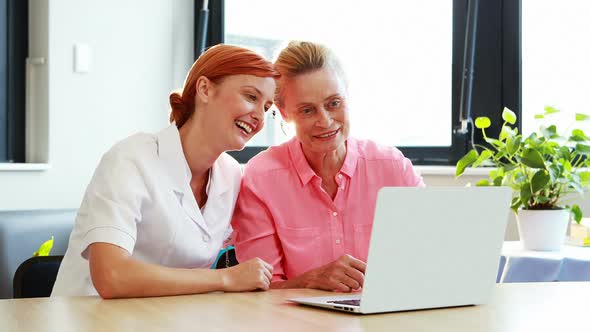 Portrait of nurse and a senior patient using laptop