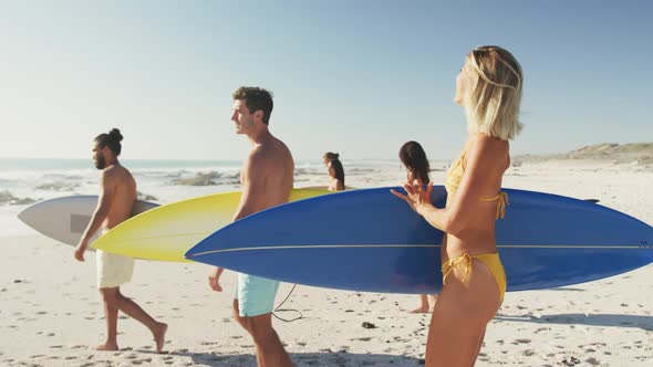 Side view of mixed race friends ready to go surf