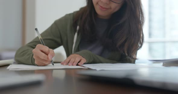 Woman do revision with cellphone at home