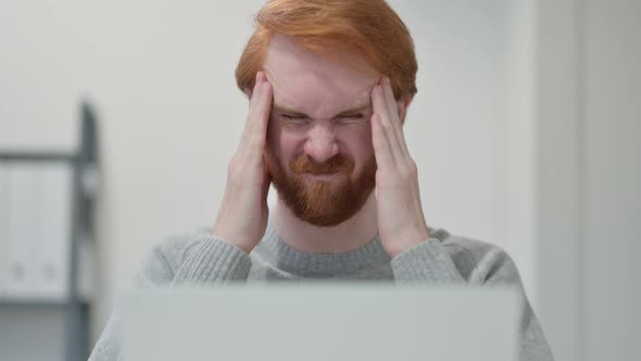 Portrait of Redhead Man Having Headache While Using Laptop 