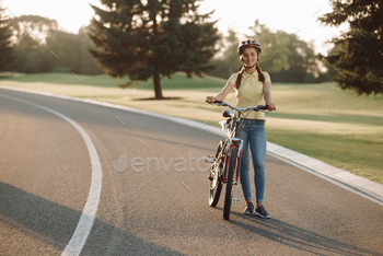 Young beautiful woman with bicycle outdoors. / Photodune, Misc